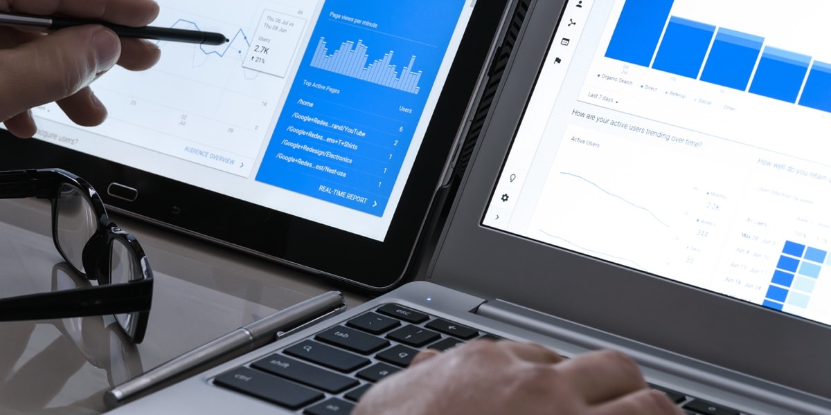 Office workers hands examining a screen displaying data analytics