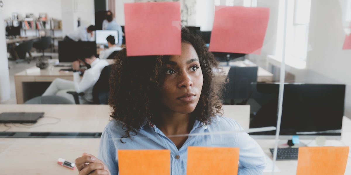 A UX researcher using the UX design process while mapping design on post-its