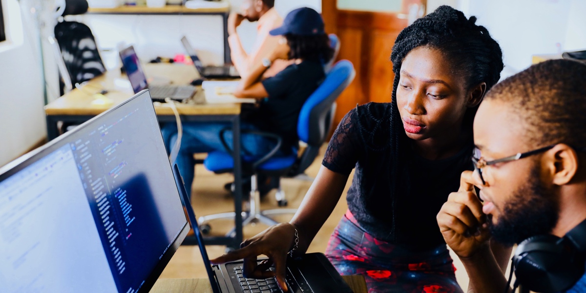 Two UX designers looking at a computer screen