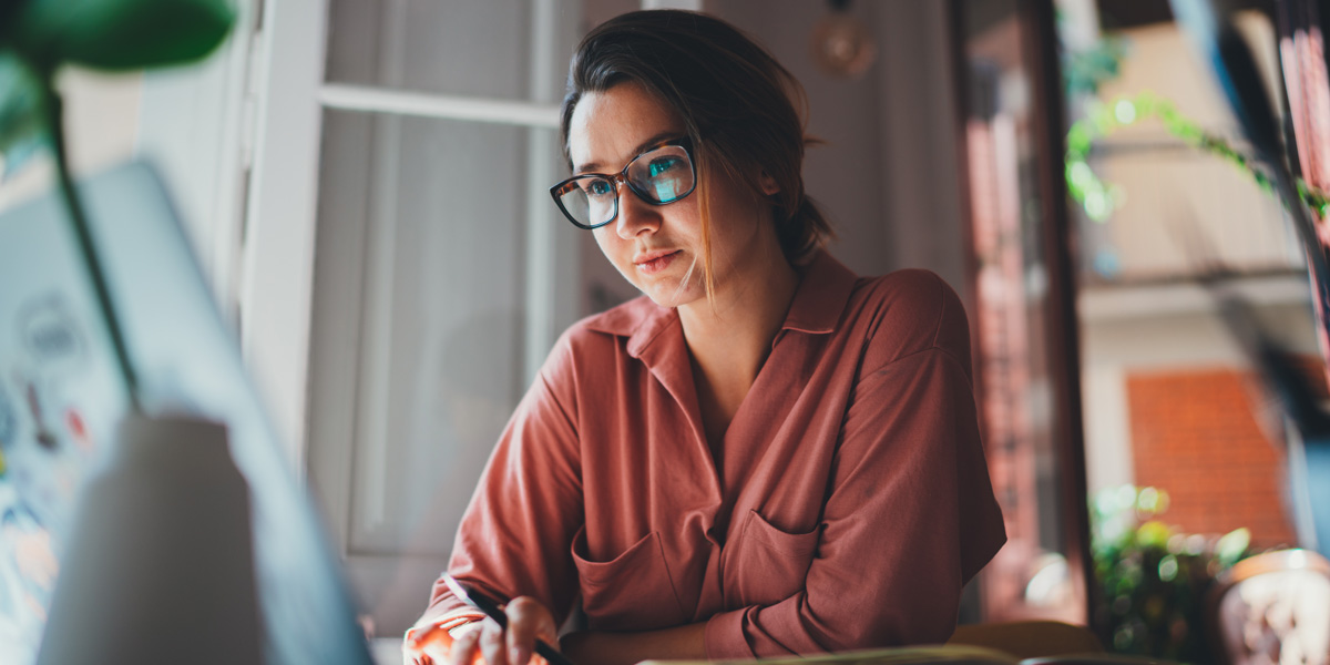 Young woman looks up free UX design training resources and free UX design bootcamps on her computer