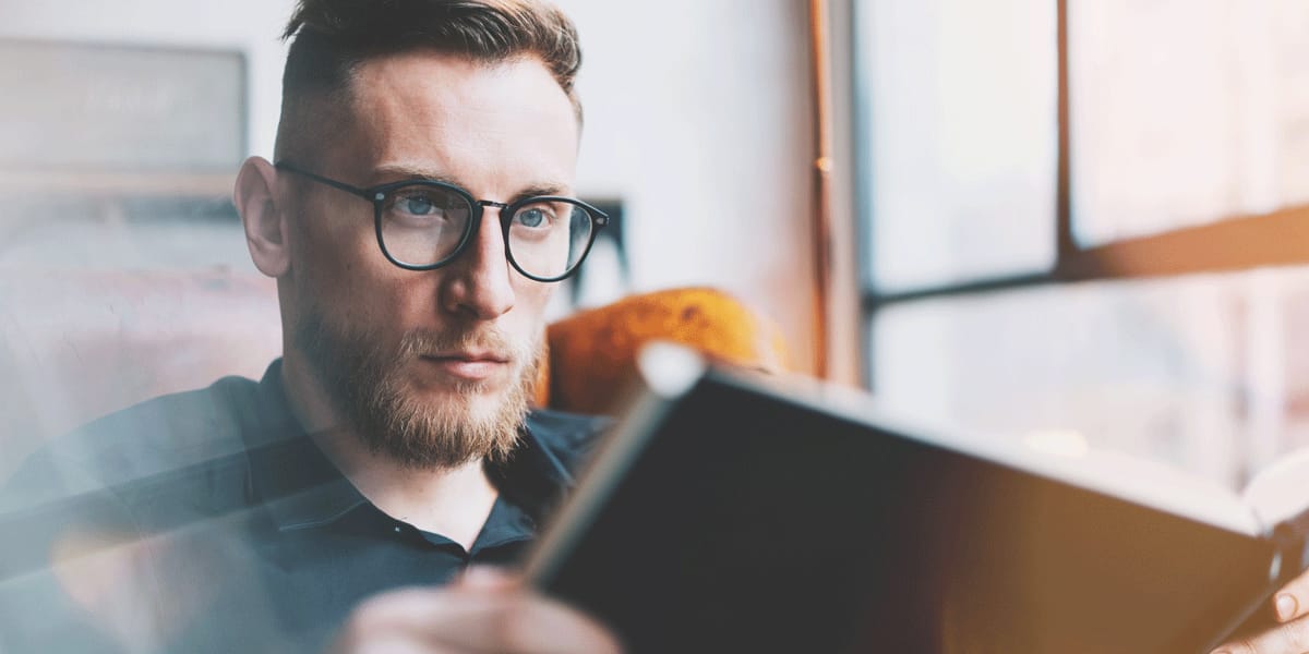 A UX researcher reading a book on user experience research