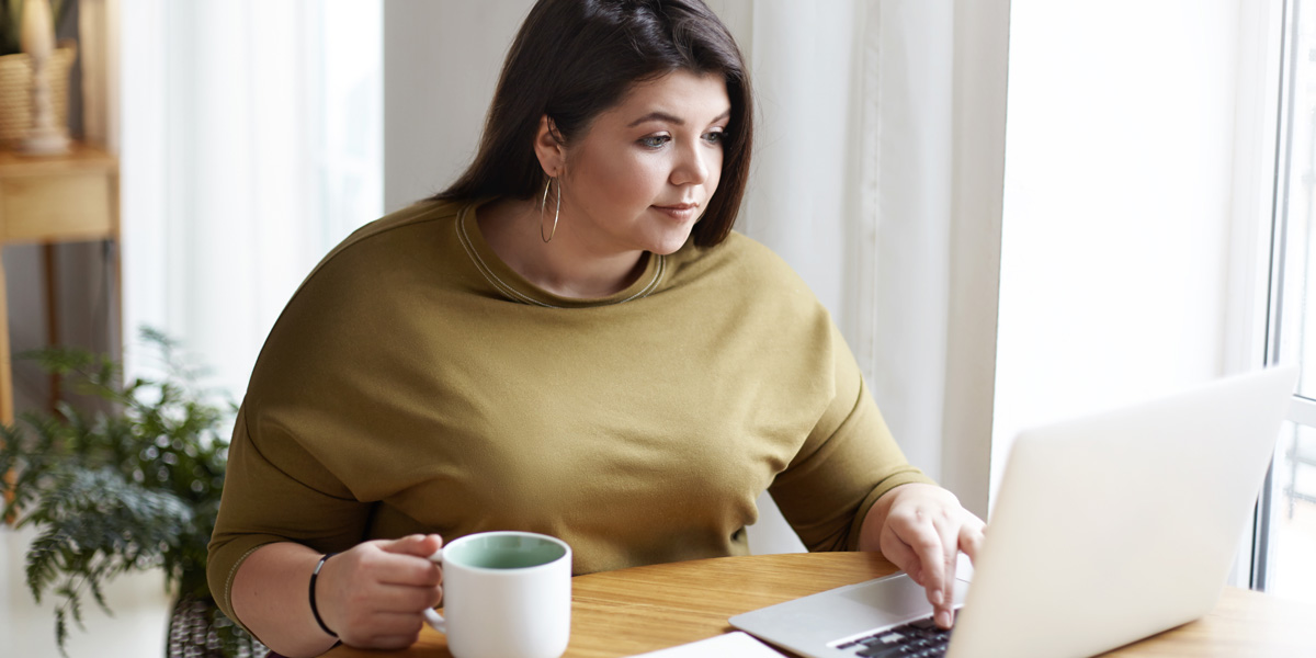 Aspiring UX designer sitting at a laptop researching UX schools